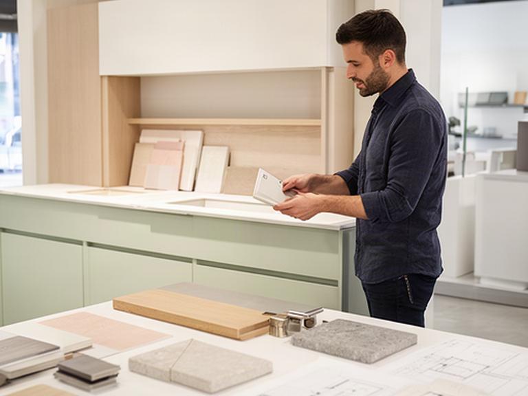 Progettista di Mancini Design che studia una cucina su misura nello showroom di Treviolo